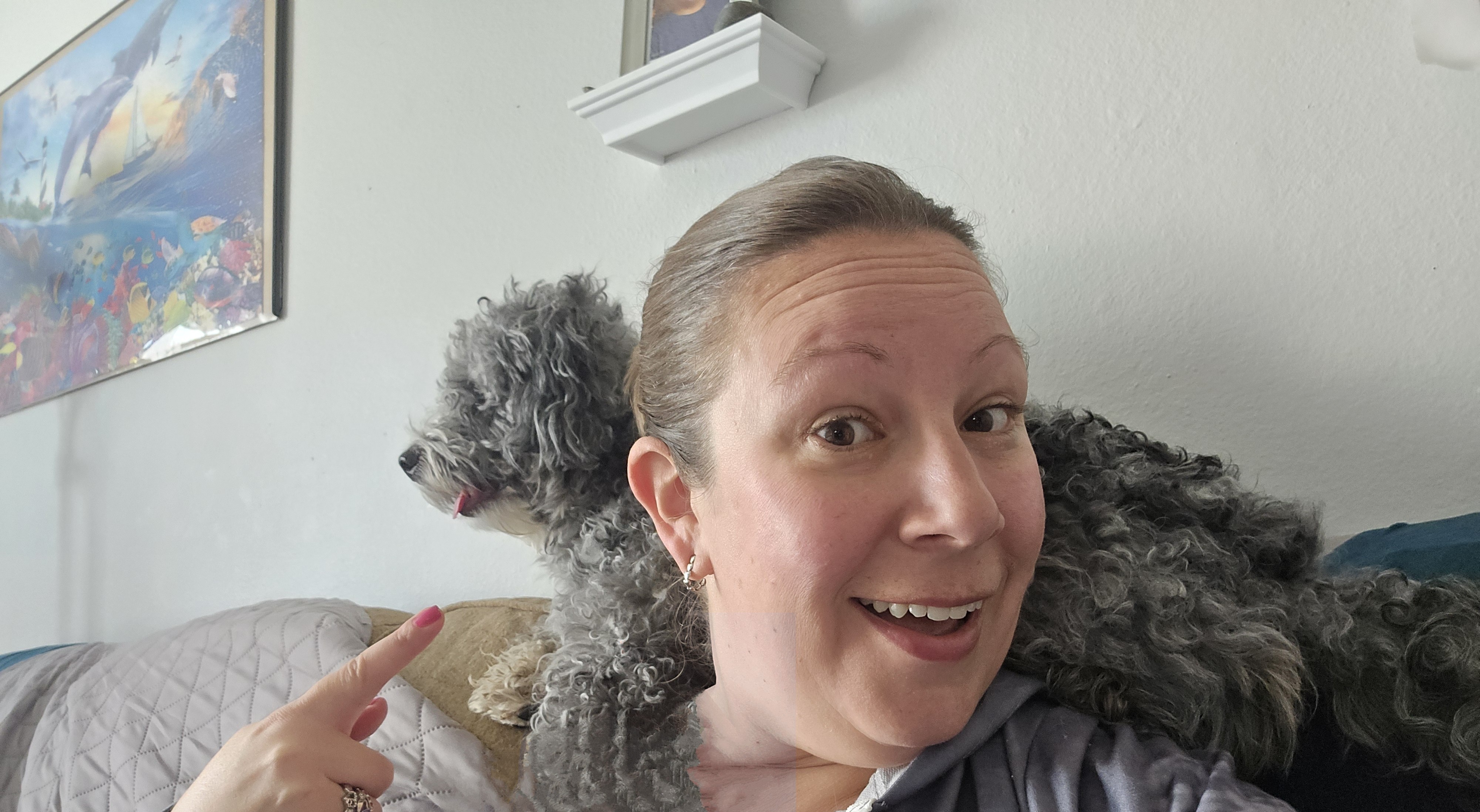 Caitlin with a fluffy gray dog on her shoulder