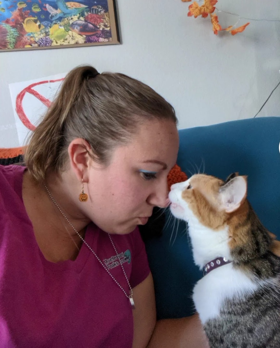Caitlin sharing a nose boop with a calico cat