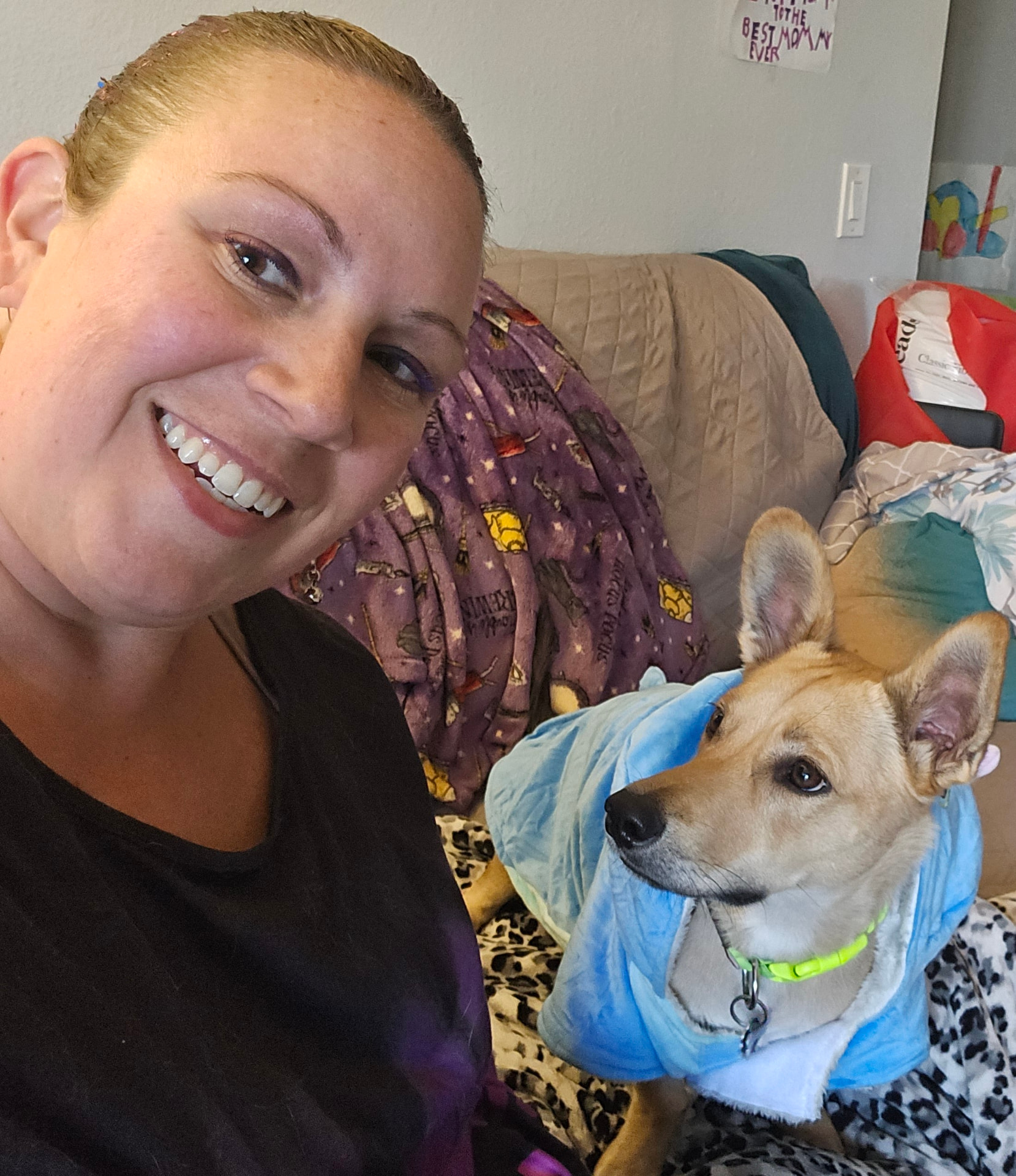 Caitlin with a tan dog wearing a cozy blue hoodie